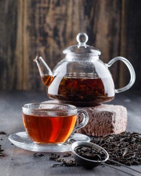 black-tea-teapot-cup-with-dry-tea-brick-side-view-wooden-surface